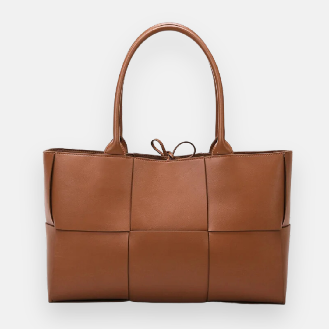 Bolsa marrom com design tramado em couro, alças duplas e detalhe de laço decorativo, ideal para um estilo moderno e sofisticado