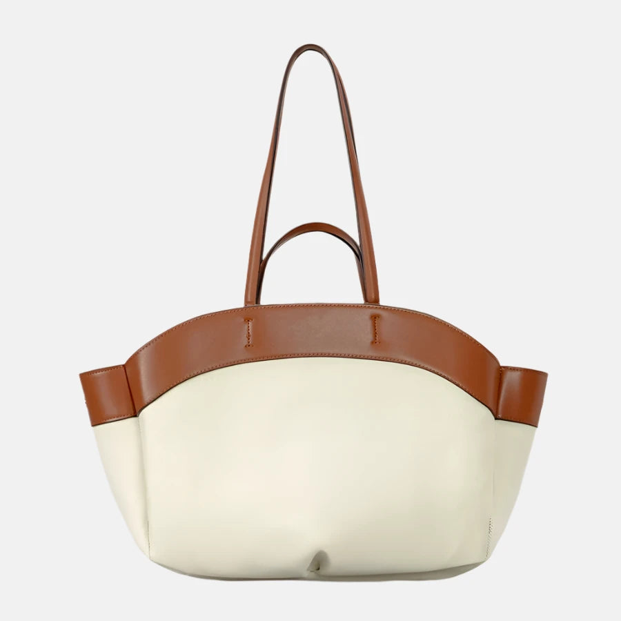 Bolsa grande bicolor em tons de branco e marrom, com alças duplas e detalhes em couro, apresentando um design elegante e espaçoso, ideal para uso diário ou ocasiões formais.