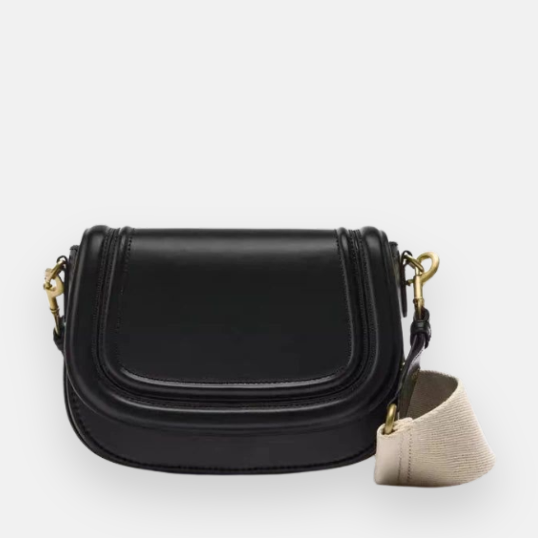 Bolsa preta em couro com design estruturado, aba frontal arredondada, detalhes em metal dourado e alça de tecido removível, ideal para um estilo clássico e versátil.