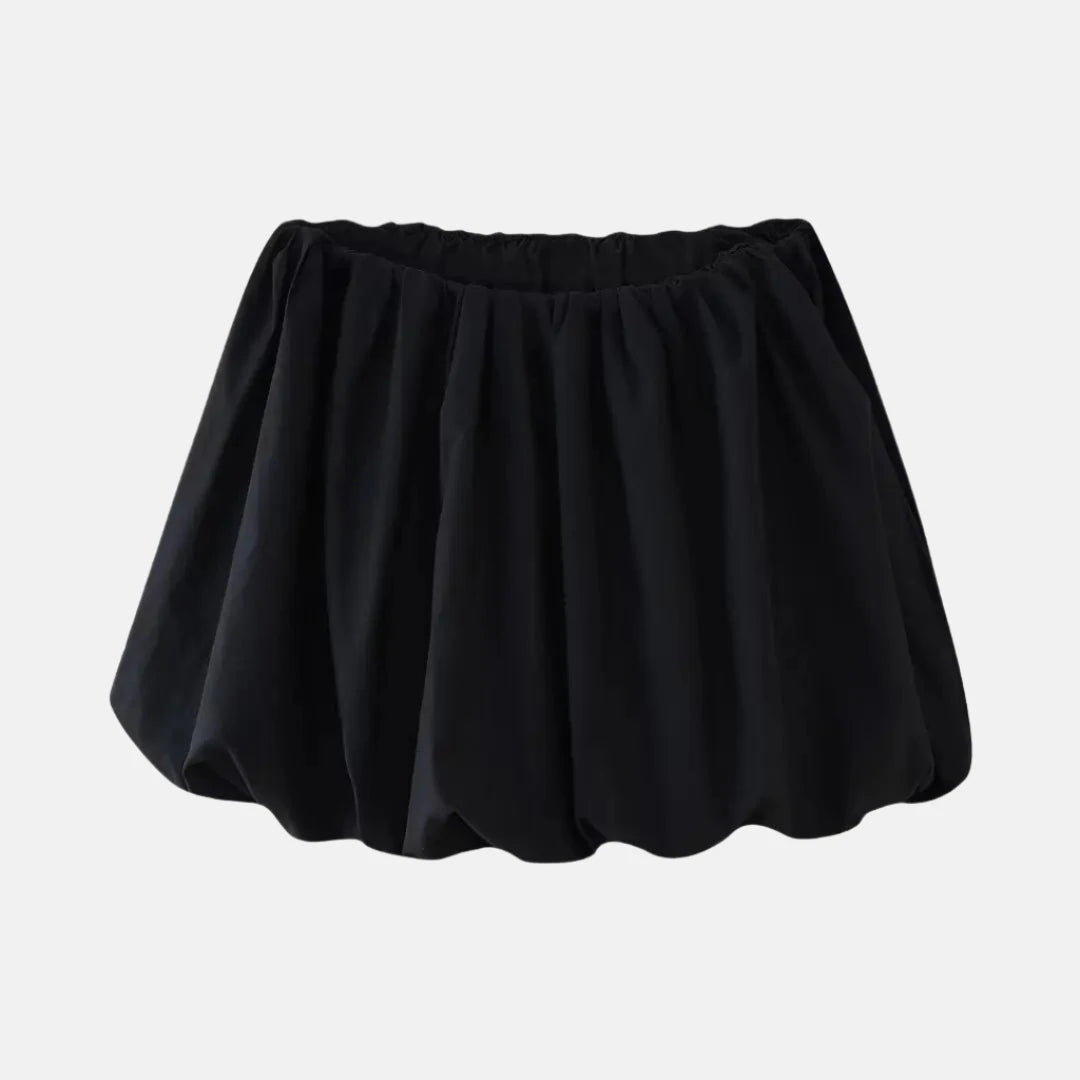 Saia curta preta com design volumoso e cintura elástica, criando um visual moderno e descontraído, ideal para diferentes ocasiões.