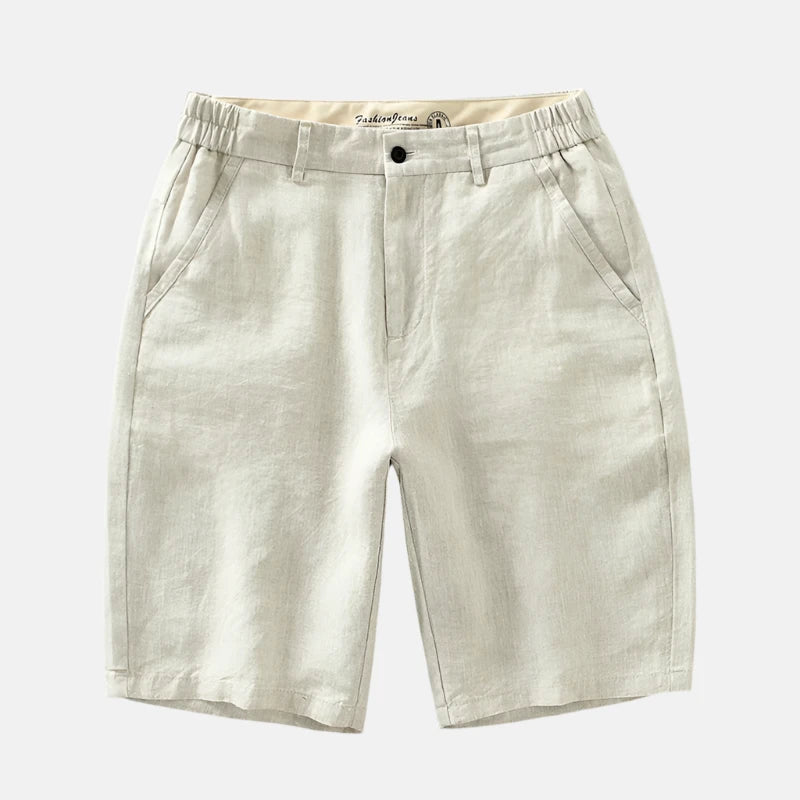 Short Pure Comodoro em linho bege claro, com cintura ajustável, bolsos laterais e traseiros. Design sofisticado, ideal para looks casuais ou sociais em dias quentes.
