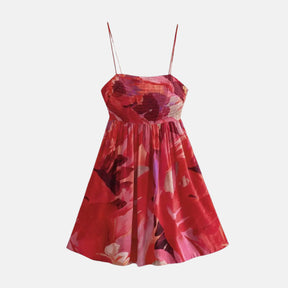 Vestido curto com estampa floral em tons de vermelho e rosa, alças finas, corpete franzido e saia ampla, ideal para um visual leve e feminino.