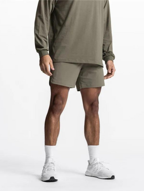 Homem vestindo o Short Esporte Haney na cor verde oliva, com design leve e respirável. Ideal para treinos, possui bolsos laterais e cintura elástica ajustável.
