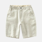 Short Pure Comodoro em linho bege claro, com cintura ajustável, bolsos laterais e traseiros. Design sofisticado, ideal para looks casuais ou sociais em dias quentes.